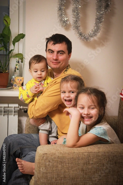 Fototapeta Father having fun with three funny children at home on New Year