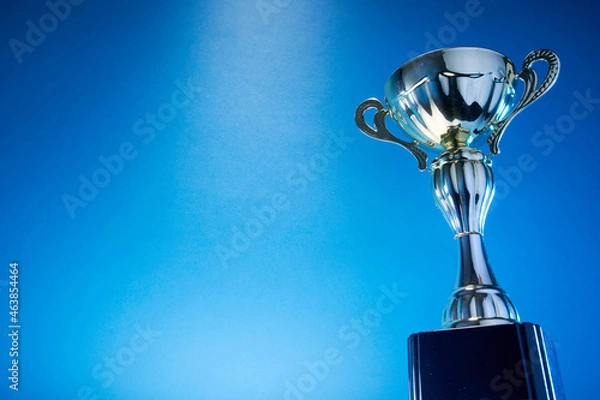 Fototapeta low angle view of winning trophy against blue background