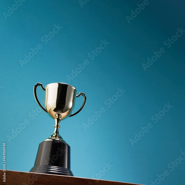 Fototapeta low angle view of winning trophy agaist blue background