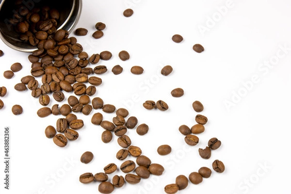 Fototapeta Roasted coffee beans on a white background. Overturned coffee can, coffee beans scattered on the table