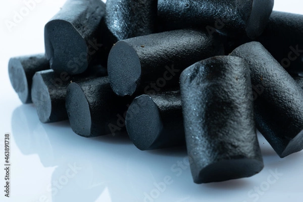 Fototapeta Closeup of a bunch of Finnish black licorice against a bright white background