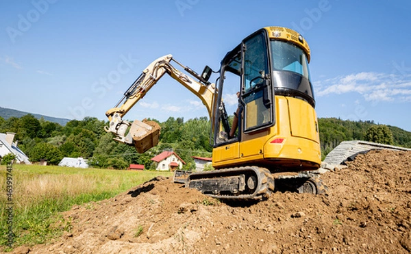 Obraz Mini excavator digging preparing ground under home garden