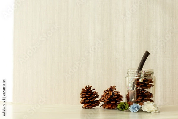 Obraz 空き瓶に松ぼっくりや小枝を入れて隅に配置したイメージ