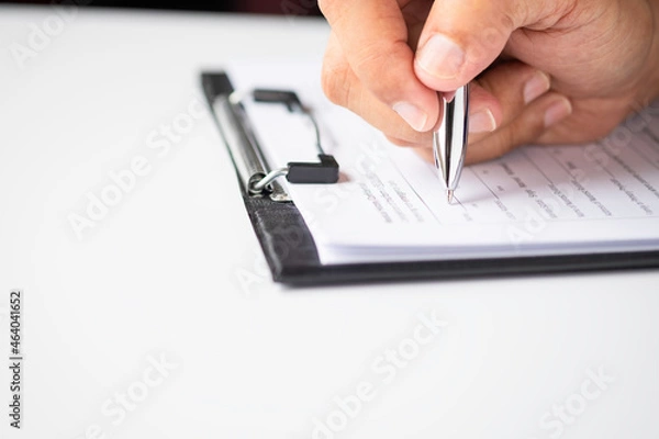 Fototapeta Image of Hand using writing pen with questionnaire or paperwork survey question filling in business company personal information form checklist document.