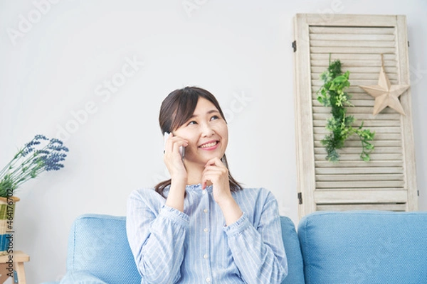 Fototapeta 部屋で電話する女性