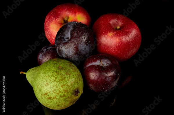 Fototapeta Red apple, green pear and plum on a black background. Water droplets on fresh fruit