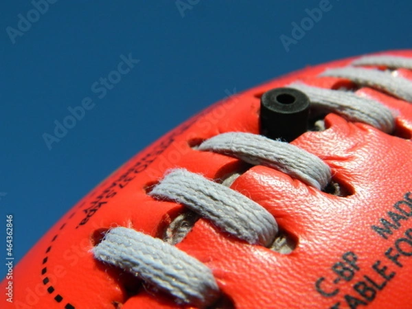 Fototapeta Close up of an Australian rules football on a blue sky background