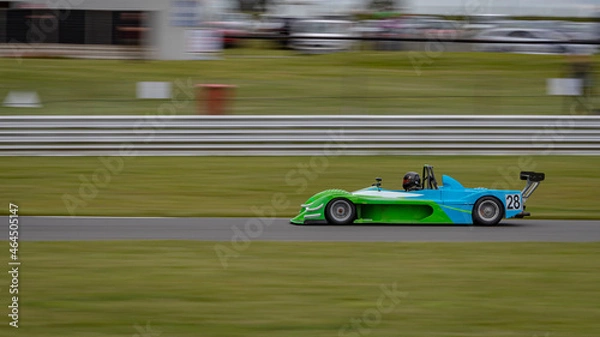 Fototapeta A panning shot of a racing car as it circuits a track.