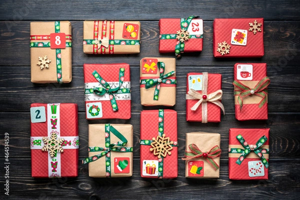 Fototapeta Handmade wrapped red, green gift boxes decorated with ribbons, snowflakes and numbers, Christmas decorations and decor on table Xmas advent calendar concept Top view Flat lay Holiday card
