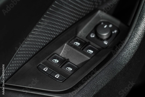 Fototapeta Close up view of button controlling window in modern car interior. Vehicle interior detail. Door handle with windows controls