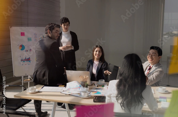 Fototapeta Group young business people, Are meeting with concentration. In conference room where documents, computers present the work of team. To work successfully, planning and strategy meetings are required.