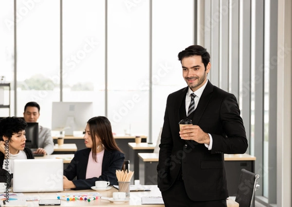 Fototapeta Handsome business man, CEO, business executive. Stand in the office and smile with happiness. Employees in the office work hard and have good leadership good work to make the work team happy.