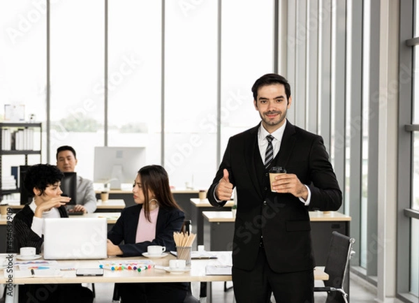 Fototapeta Handsome business man, CEO, business executive. Stand in the office and smile with happiness. Employees in the office work hard and have good leadership good work to make the work team happy.