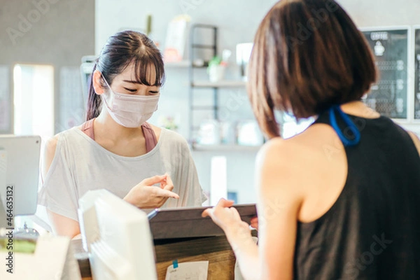 Fototapeta スポーツジムでタブレットを見る女性（マスク）
