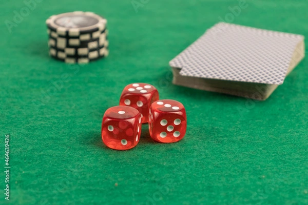 Fototapeta 3 red dice close-up on a green background