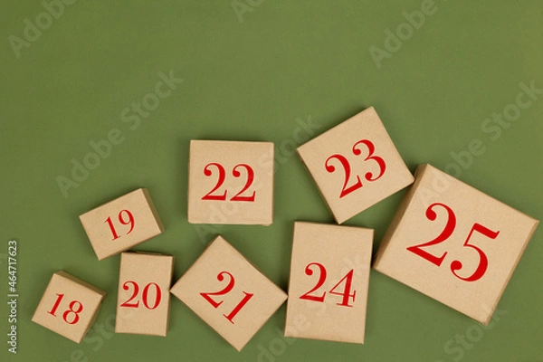 Fototapeta Christmas crafts made of paper holiday boxes on a green background. Christmas winter holiday greetings, advent calendar. flat lying