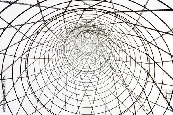 Fototapeta Bottom-up view of the Shukhov Tower on the Oka River, Nizhny Novgorod region, Russia. A beautiful web of metal structures and small.
