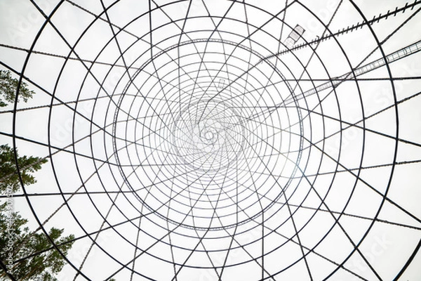 Fototapeta Bottom-up view of the Shukhov Tower on the Oka River, Nizhny Novgorod region, Russia. A beautiful web of metal structures and small.