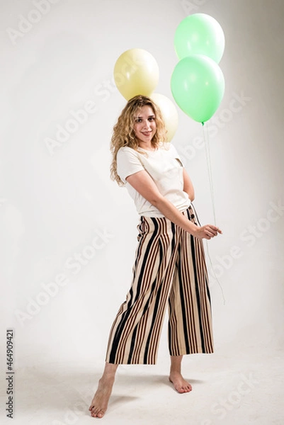 Fototapeta Funny girl with colored balls on a white background. (isolated on white)