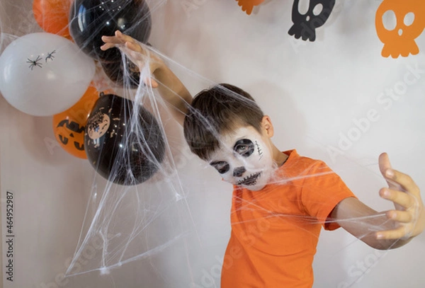 Obraz Happy baby with skeleton makeup. Spider web in the hands of a boy on Halloween
