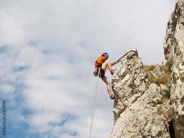 Fototapeta rapelling down a rock