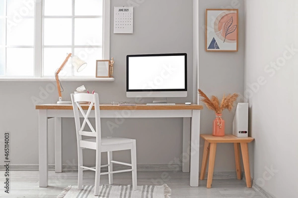 Fototapeta Modern workplace with blank computer screen in light office