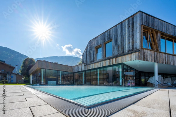 Fototapeta modern pool building with weathered wood facade with fresh turquoise water and sunbeams