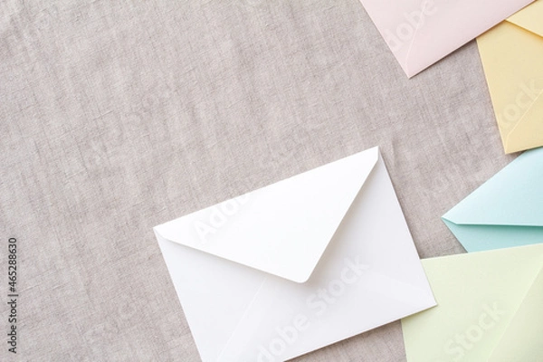 Fototapeta 明るいグレーの布の背景と俯瞰の白とカラフルな封筒