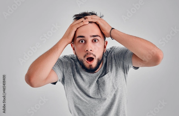 Fototapeta Young man in the studio on a gray background
