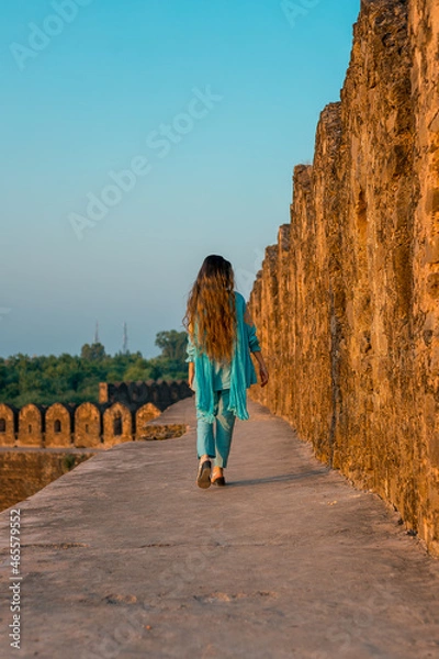 Obraz Back view of a girl in Pakistani dress walking in ancient Rohtas Fort
