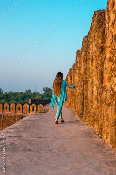Obraz Back view of a girl in Pakistani dress walking in ancient Rohtas Fort
