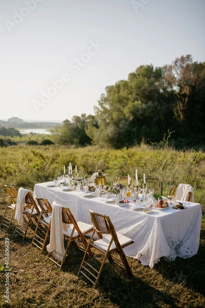Obraz Breakfast table in the garden at dawn in beautiful sunlight. Laid table with food in the garden.