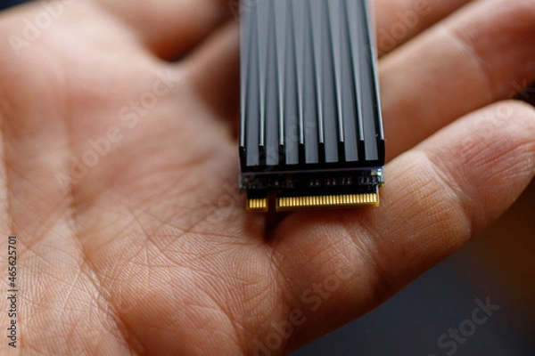 Obraz The service technician holds a new ssd drive in his hands. Close up.