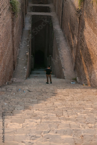 Obraz Man standing on the stairs leading towards the well in Rohtas Fort