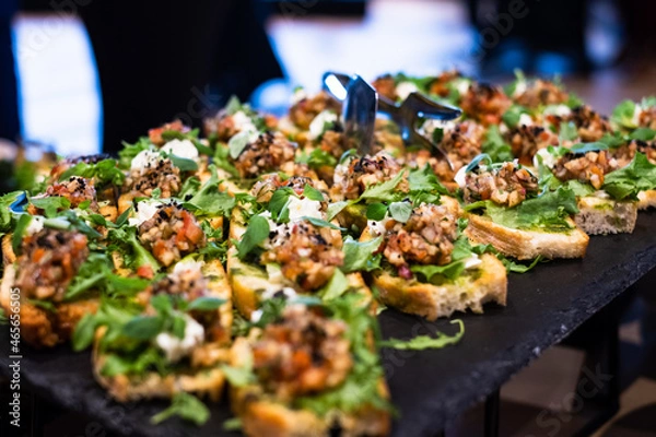 Fototapeta Bruschetta with tomato salsa and fresh basil. Italian Antipasti and snacks served at catering event or party.