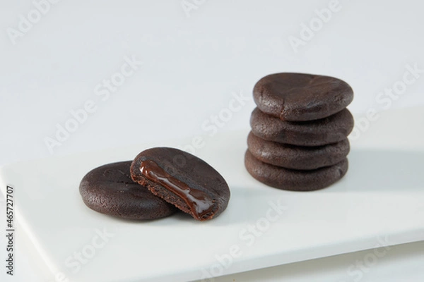 Fototapeta Biscuits filled with chocolate cream. Chocolate cream cookies or Choco fills served with cup of milk