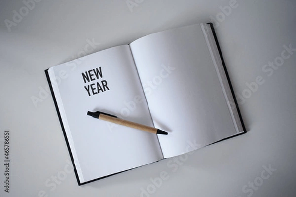 Obraz Book with pen on desk with new year heading