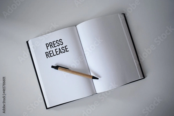 Fototapeta Book with pen on desk with press release heading