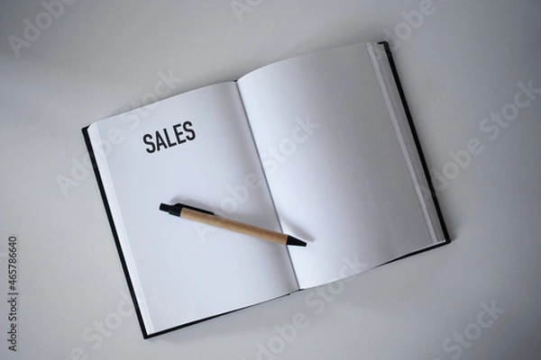 Fototapeta Book with pen on desk with sales heading