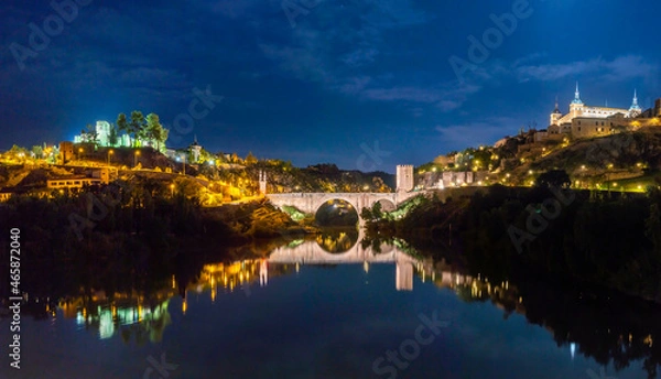 Fototapeta Night Panoramic view of the Alcázar de Toledo and the Castillo de San Servando across the Alcantara Bridge