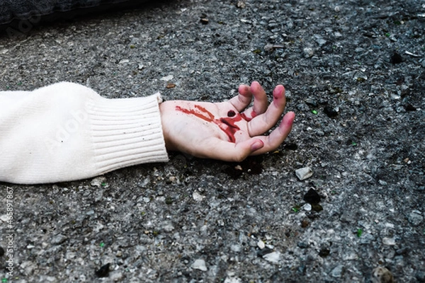 Obraz a man's hand is covered in blood lying on the asphalt on the road