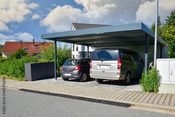 Obraz Carport für zwei Autos aus beschichtetem Metall vor einem Wohnhaus