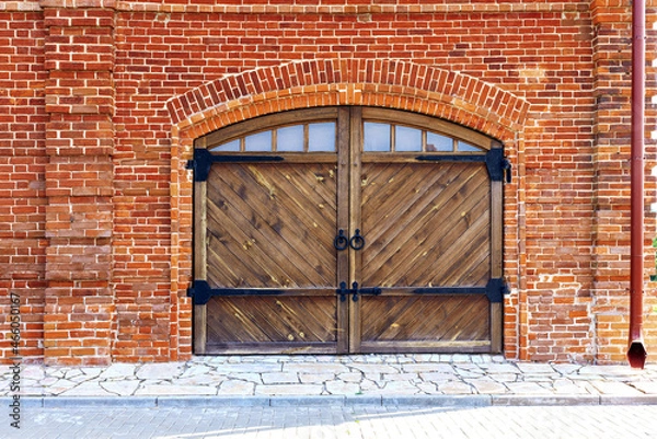 Obraz red brick wall with arch and wooden gate