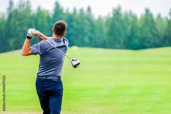 Fototapeta View from the back, a man playing golf on a forest background. High quality photo