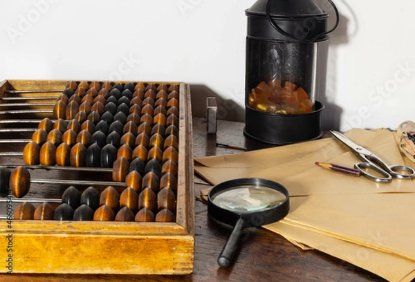 Fototapeta the post office of the last century, paper envelopes, scissors and a magnifying magnifier in the foreground, abacus on the left