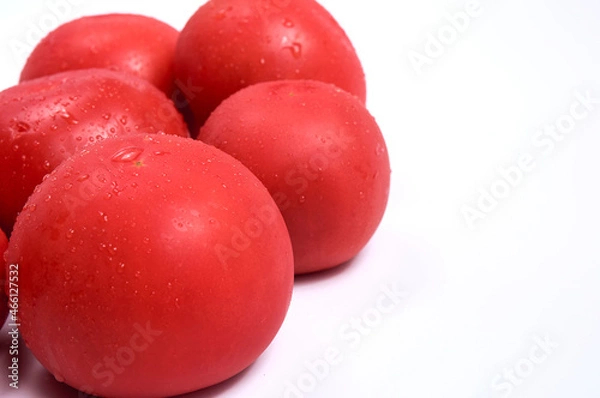Fototapeta Red tomatoes on a white background. Free space for text. Water drops on wet vegetables.