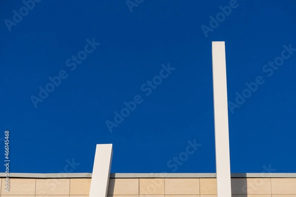 Fototapeta Abstract architectural detail of a modern office building facade isolated with blue sky background