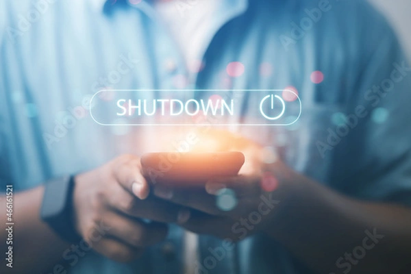 Fototapeta Businessman presses the power button via smartphone technology.
