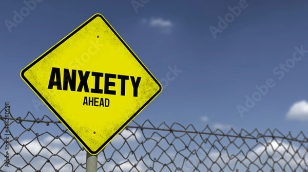 Fototapeta 3D-Illustration of a yellow warning sign that says 'ANXIETY AHEAD' in front of a dark sky