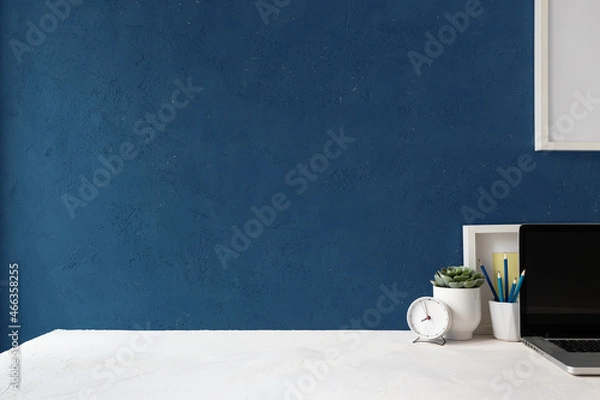 Obraz Desk with blue wall and white table mock up..
